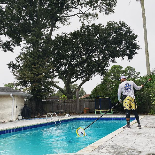 Man Removing Dirt on the Pool — New Orleans, LA — Blue Street Pools Man Removing Dirt on the Pool — New Orleans, LA — Blue Street Pools