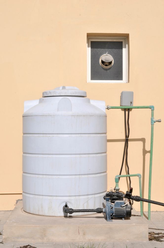 A White Water Tank Is Sitting In Front Of A Building Next To A Window — Ashley Chick Plumbing In Baranduda, VIC