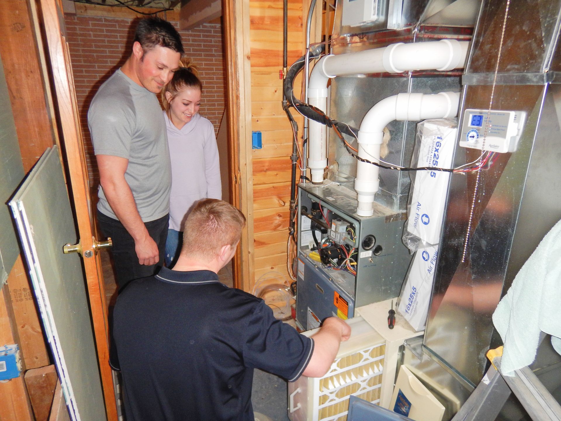 The House Inspector checking the Heating System together with the Couple - Milton, WI - Home Pro Inspection Services Inc.