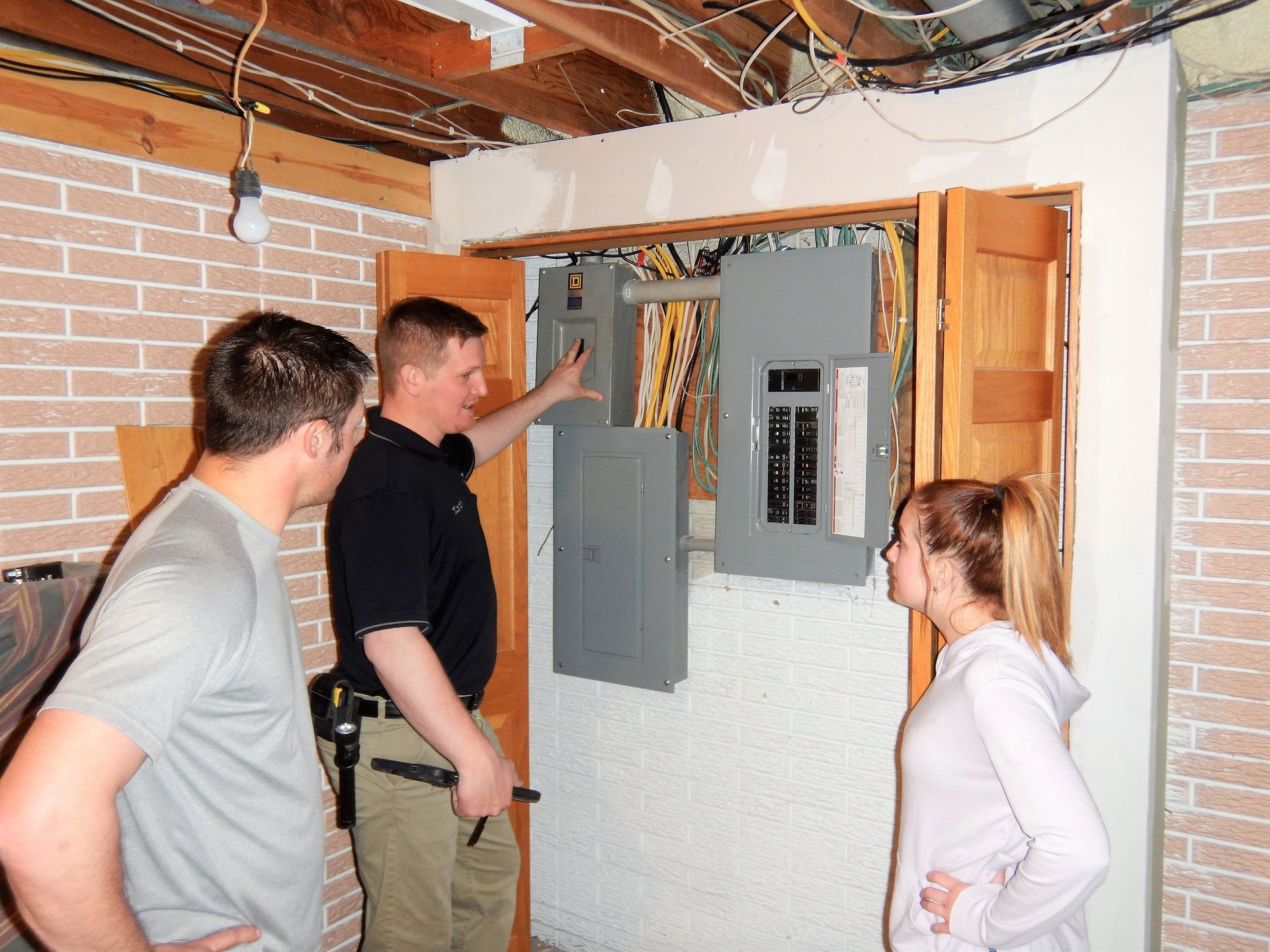 Two Men and a Woman are looking at an Electrical Box - Milton, WI - Home Pro Inspection Services Inc.