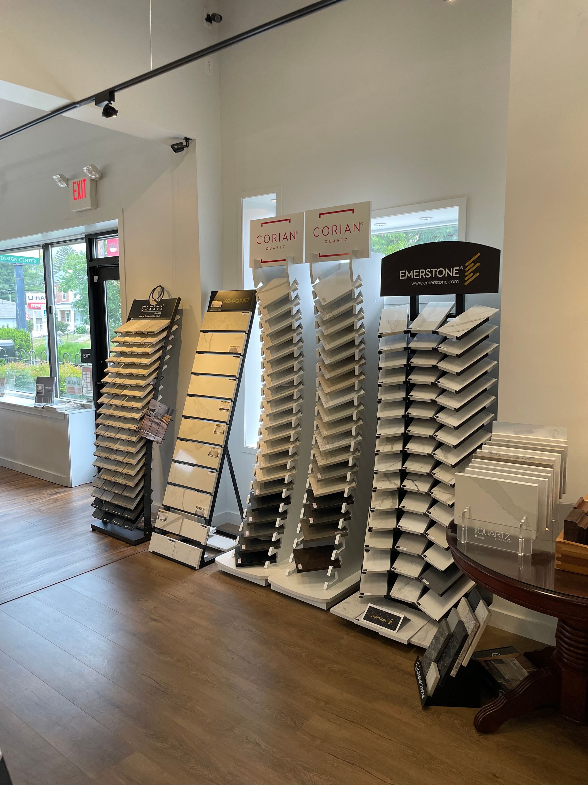 Floor display of stacked product samples and brochures in a bright retail showroom.