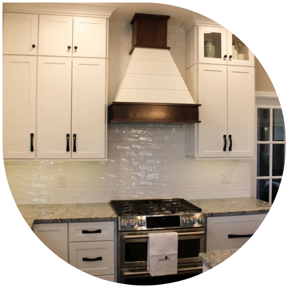 Modern kitchen with white cabinets, beige countertops, tiled backsplash, and stainless steel stove and hood