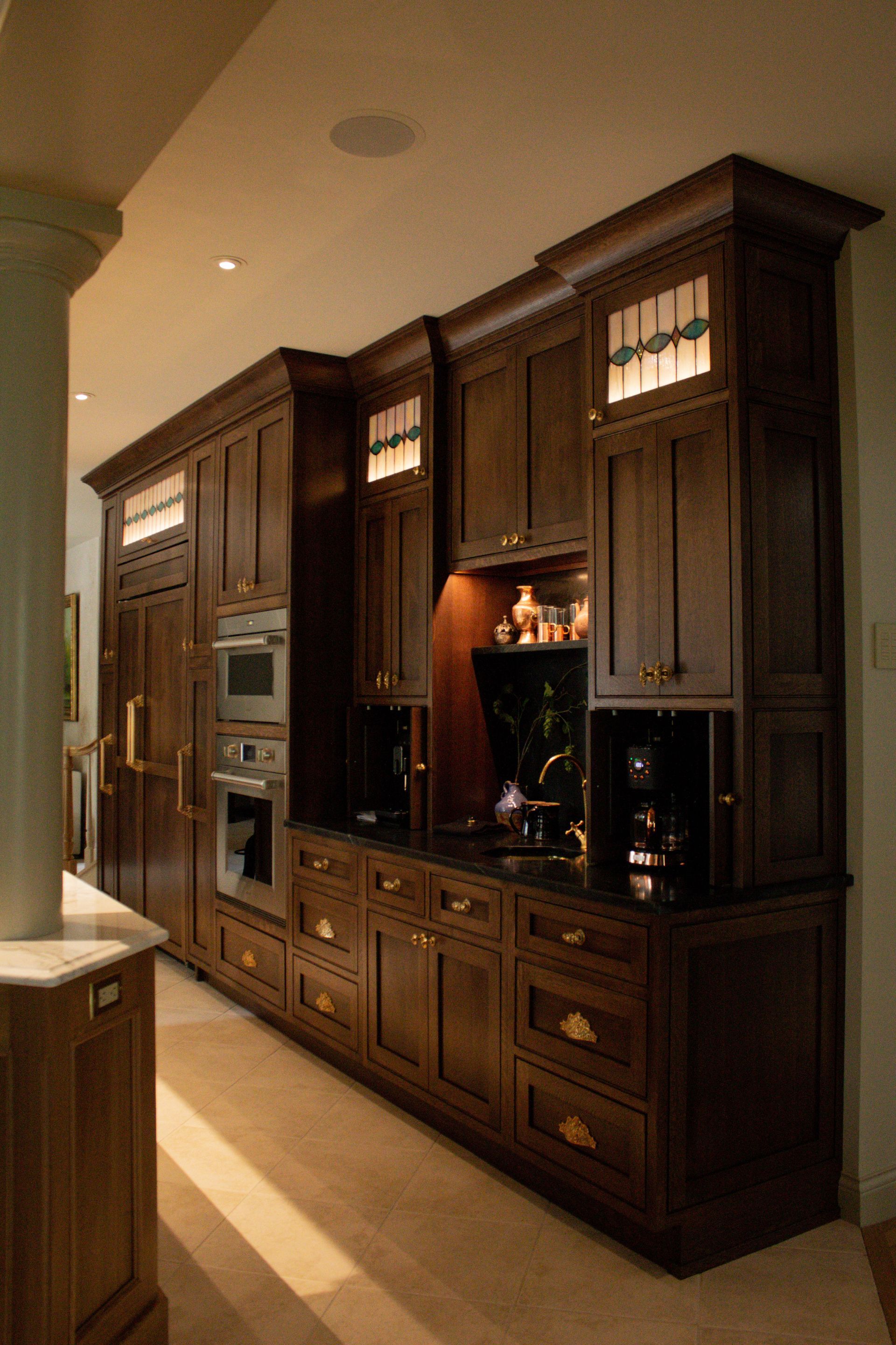 Dark wooden built-in cabinets and shelves along a hallway wall, with a lit display niche and drawers.