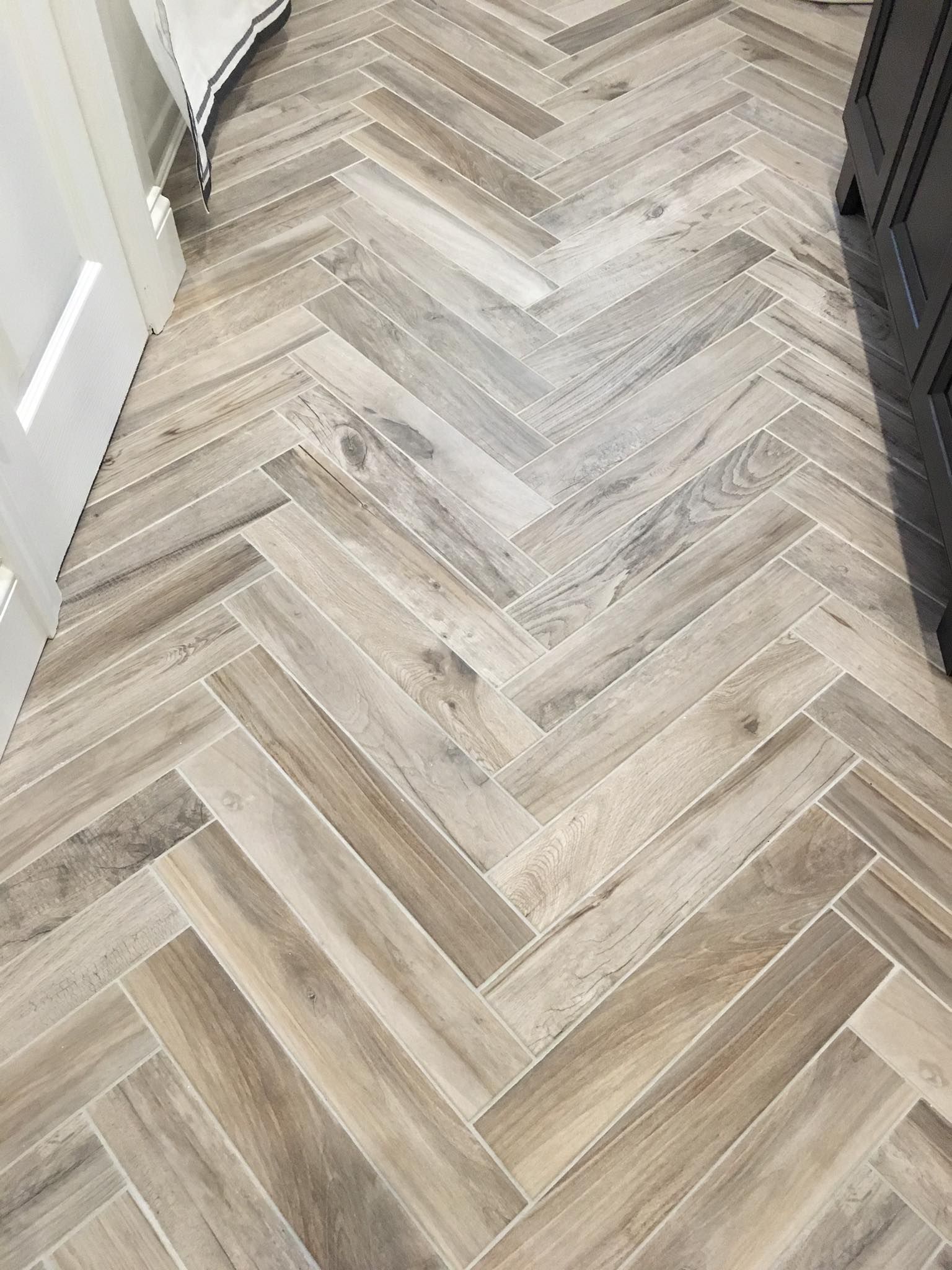 Light wood herringbone flooring in a hallway, viewed from above