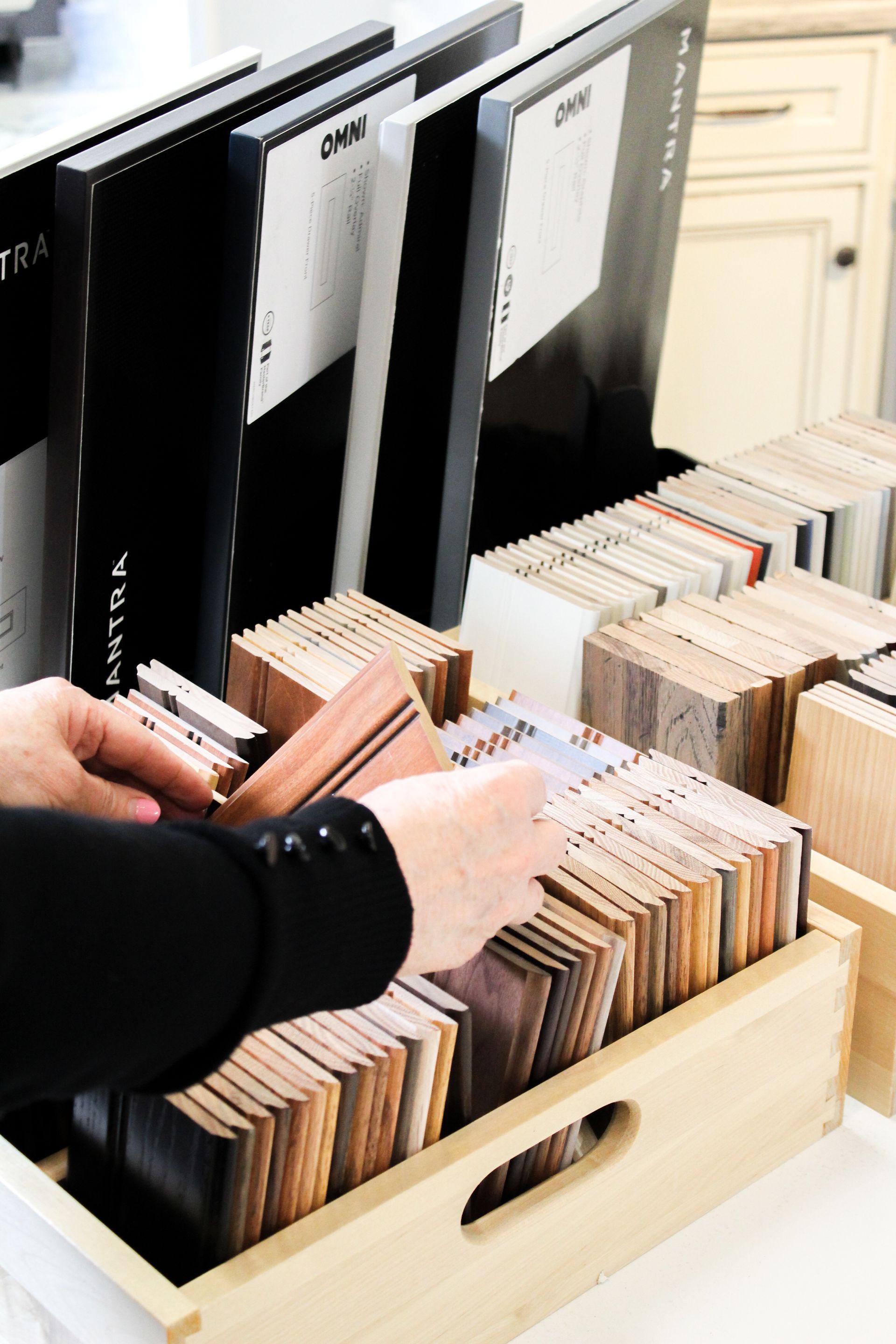 Hands sorting records in a wooden bin with black and white dividers
