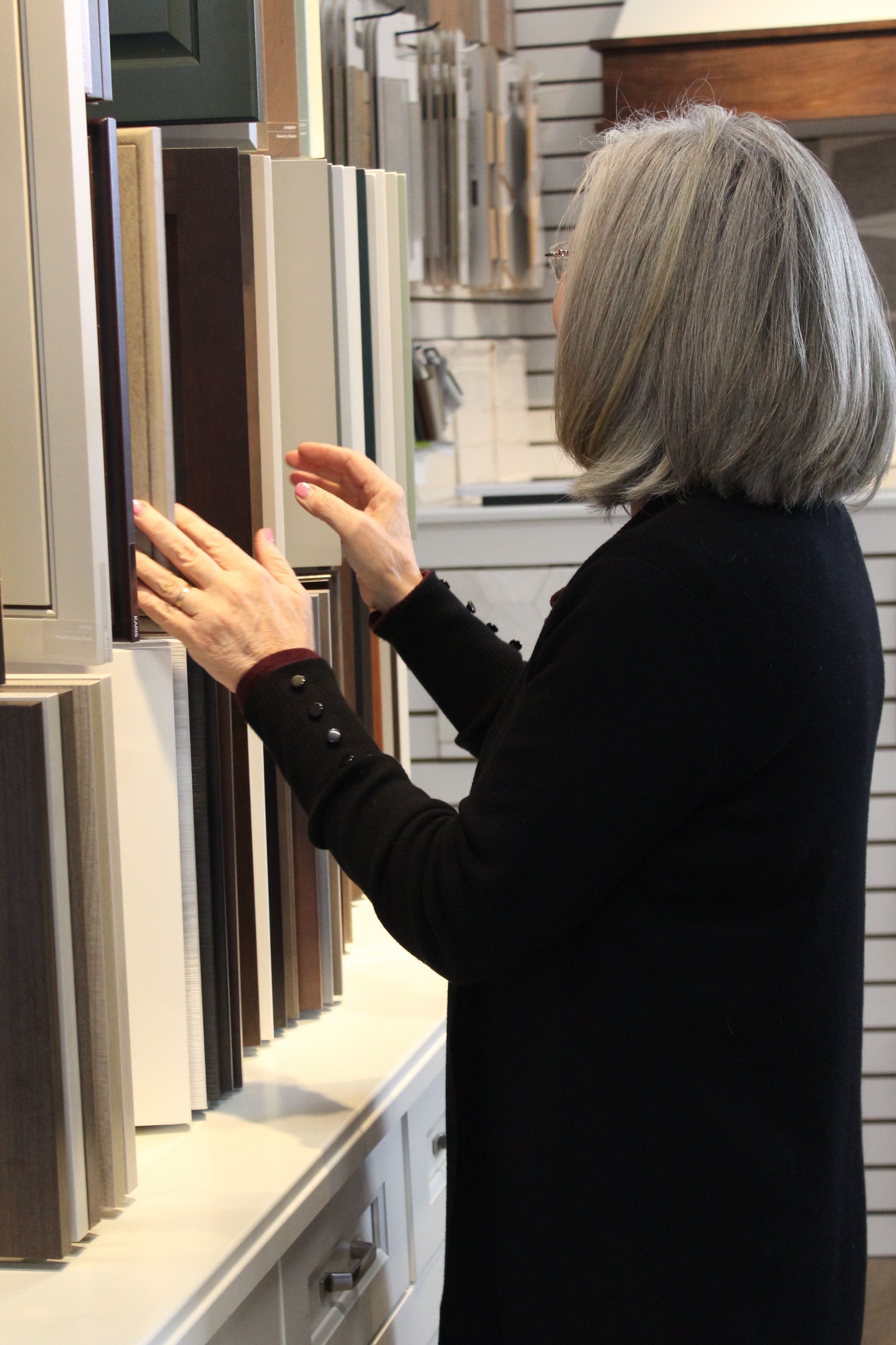 Person browsing samples on a display wall in a showroom