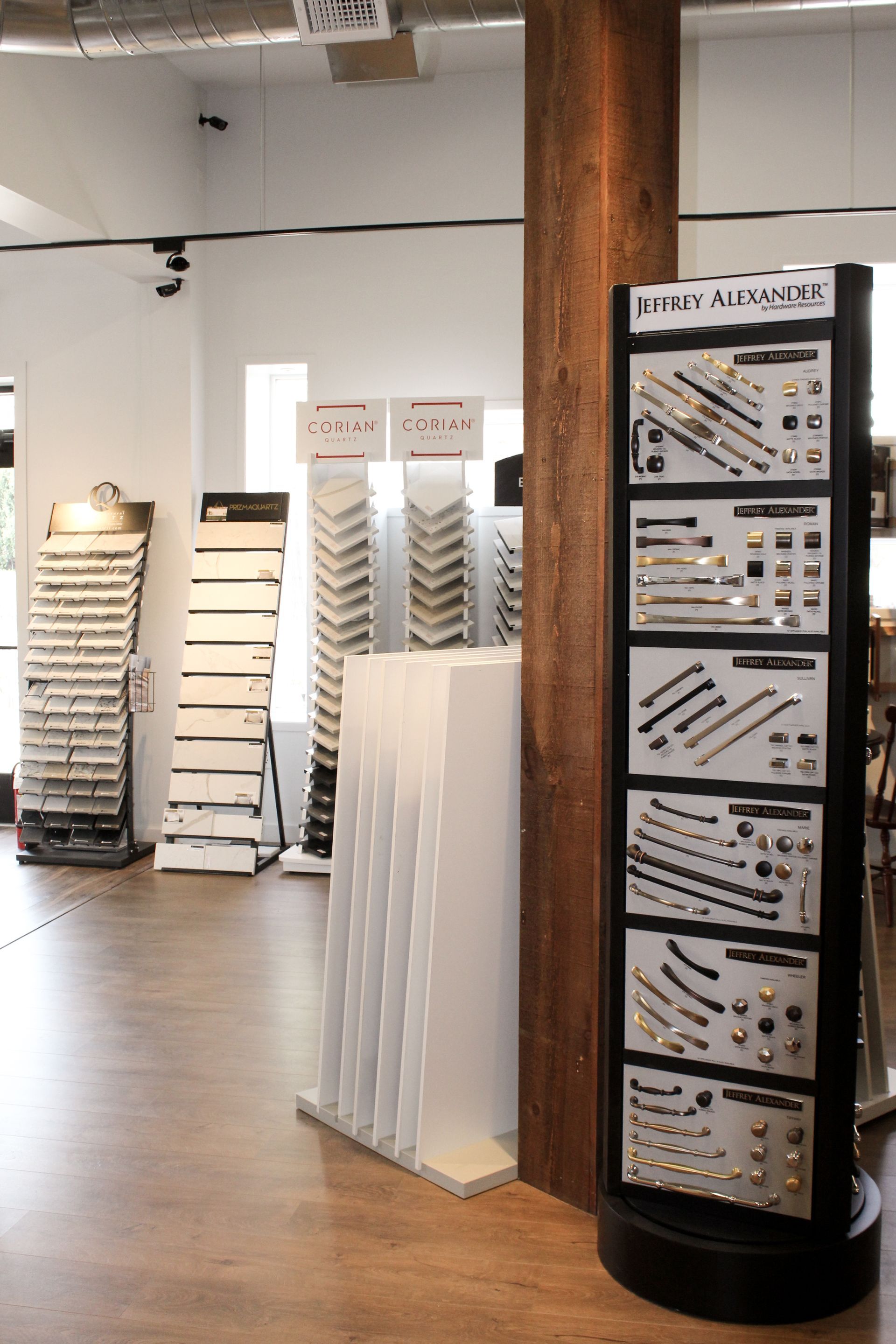 Showroom of flooring and tile samples displayed on racks and a central column stand