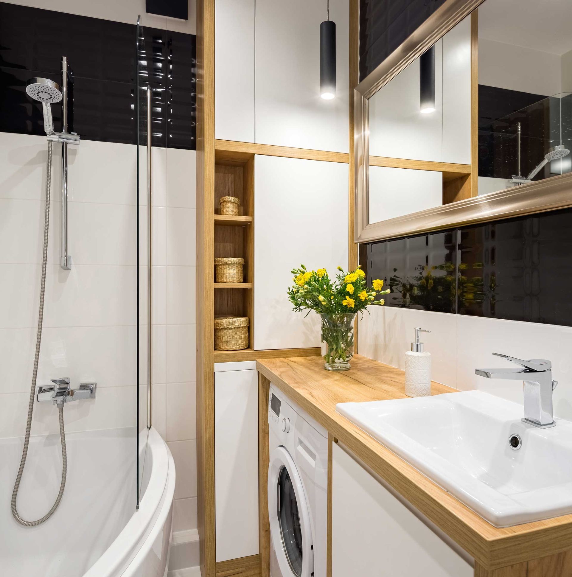 Modern bathroom with bathtub, shower, vanity sink, mirror, and wood countertop accents