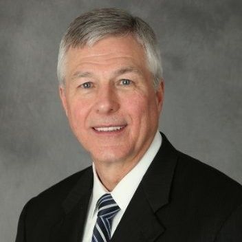 A man in a suit and tie is smiling for the camera.