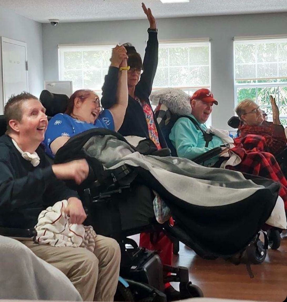 Safehaven event with a resident and caretaker holding hands in the air