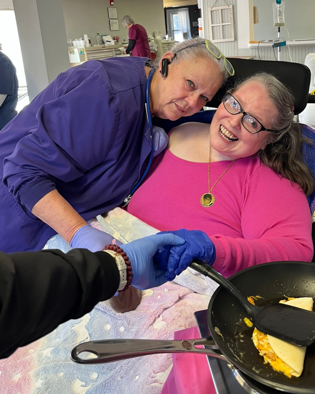 JSF caregiver and resident smiling at the camera with glasses on