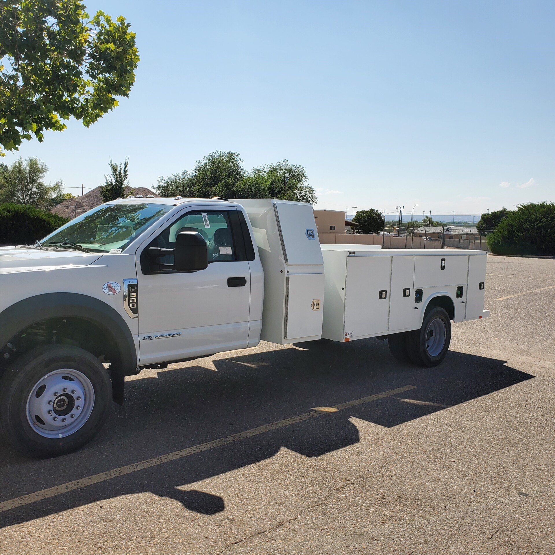 White work truck parked in a paved lot on a sunny day.