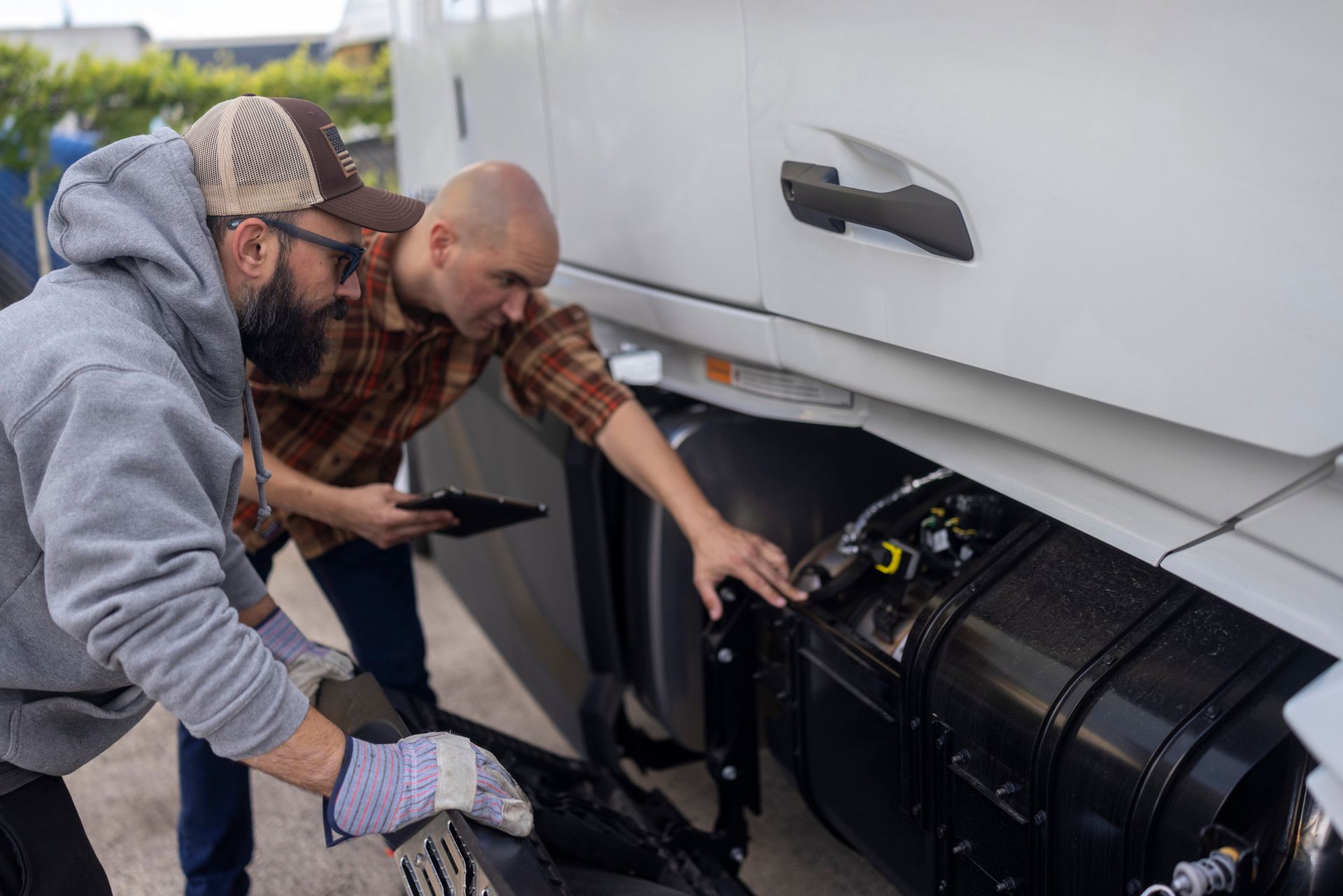 A truck driver explains to a mechanic what is wrong with the truck's engine.