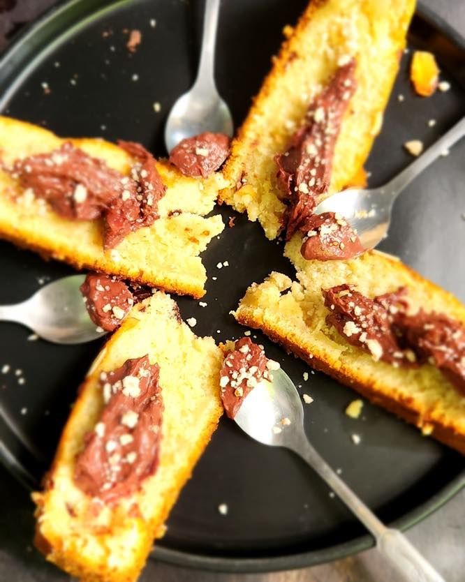 Chocolate-topped cake slices on a black plate with spoons