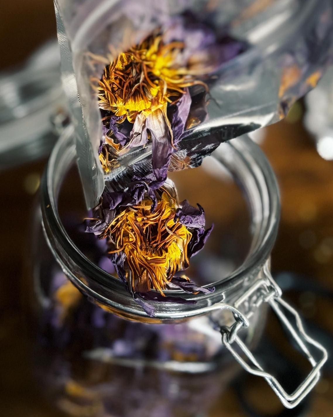 Glass jar filled with dried purple and yellow flowers, viewed from above