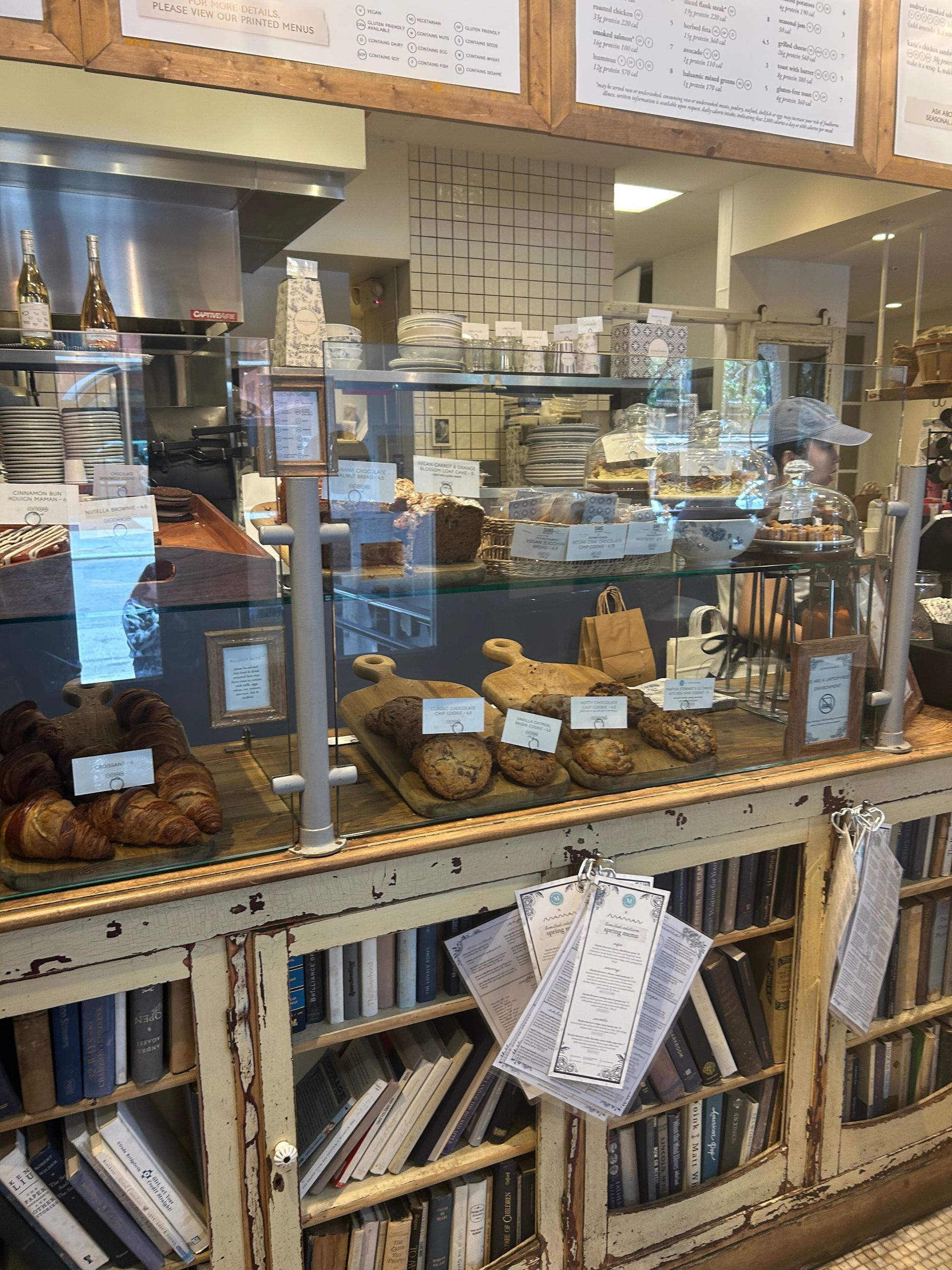 Bakery display case with assorted pastries, cakes, and bread on a counter in a shop interior