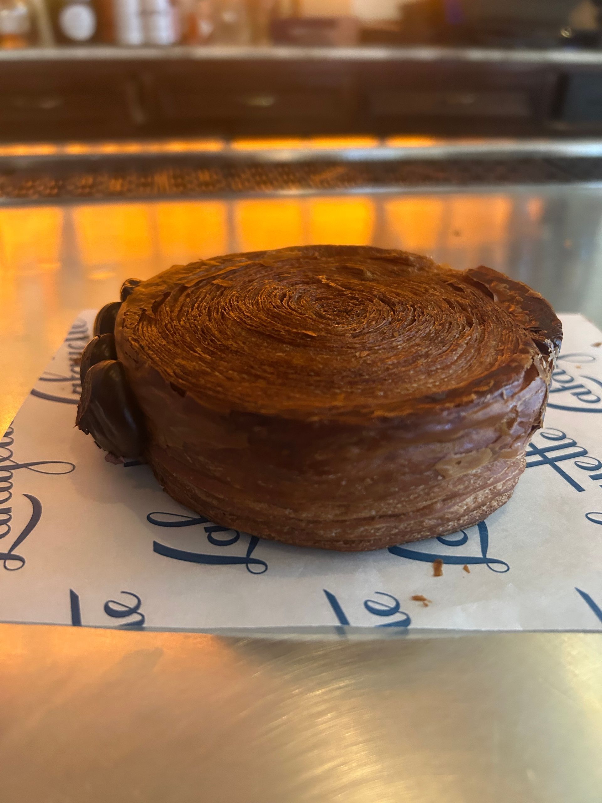 Round chocolate pastry on parchment in a bakery display case