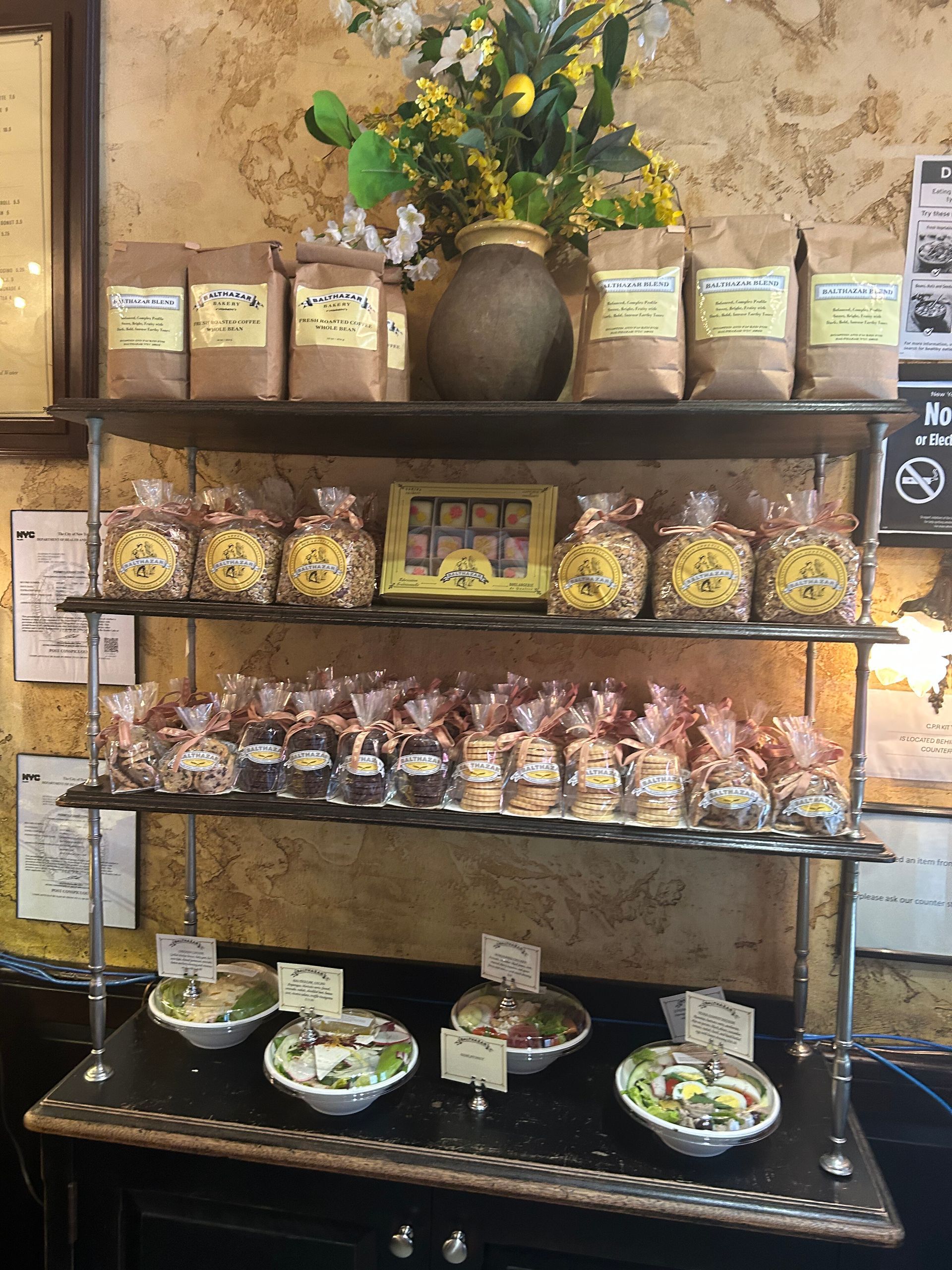 Boutique candy display on shelves with jars, wrapped treats, and small dessert plates against a rustic wall