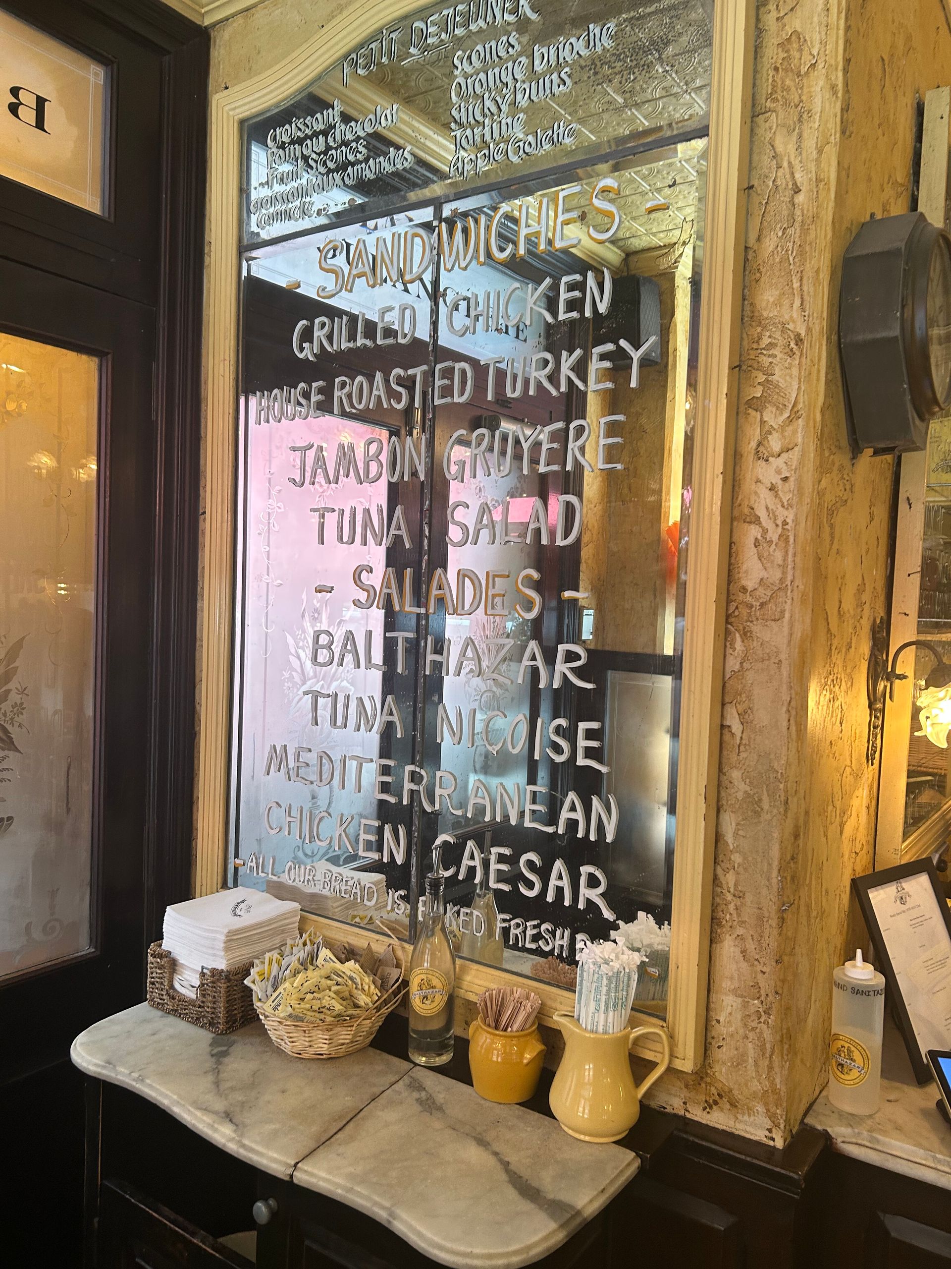 Rustic café window with handwritten menu and jars of ingredients on the sill