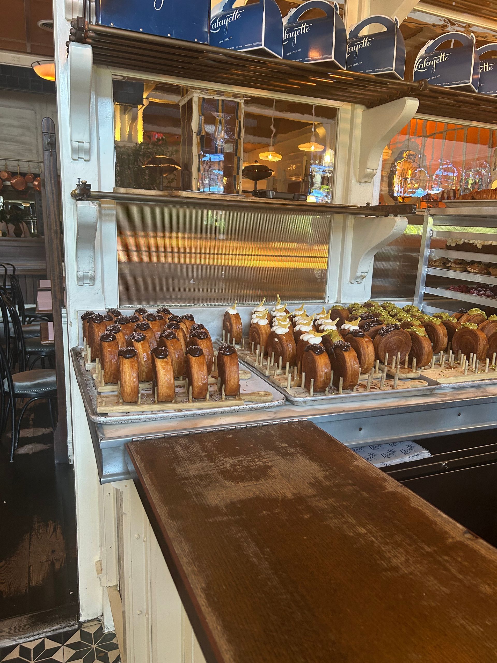 Bakery display with rows of pastries and chocolate fountain under warm lights