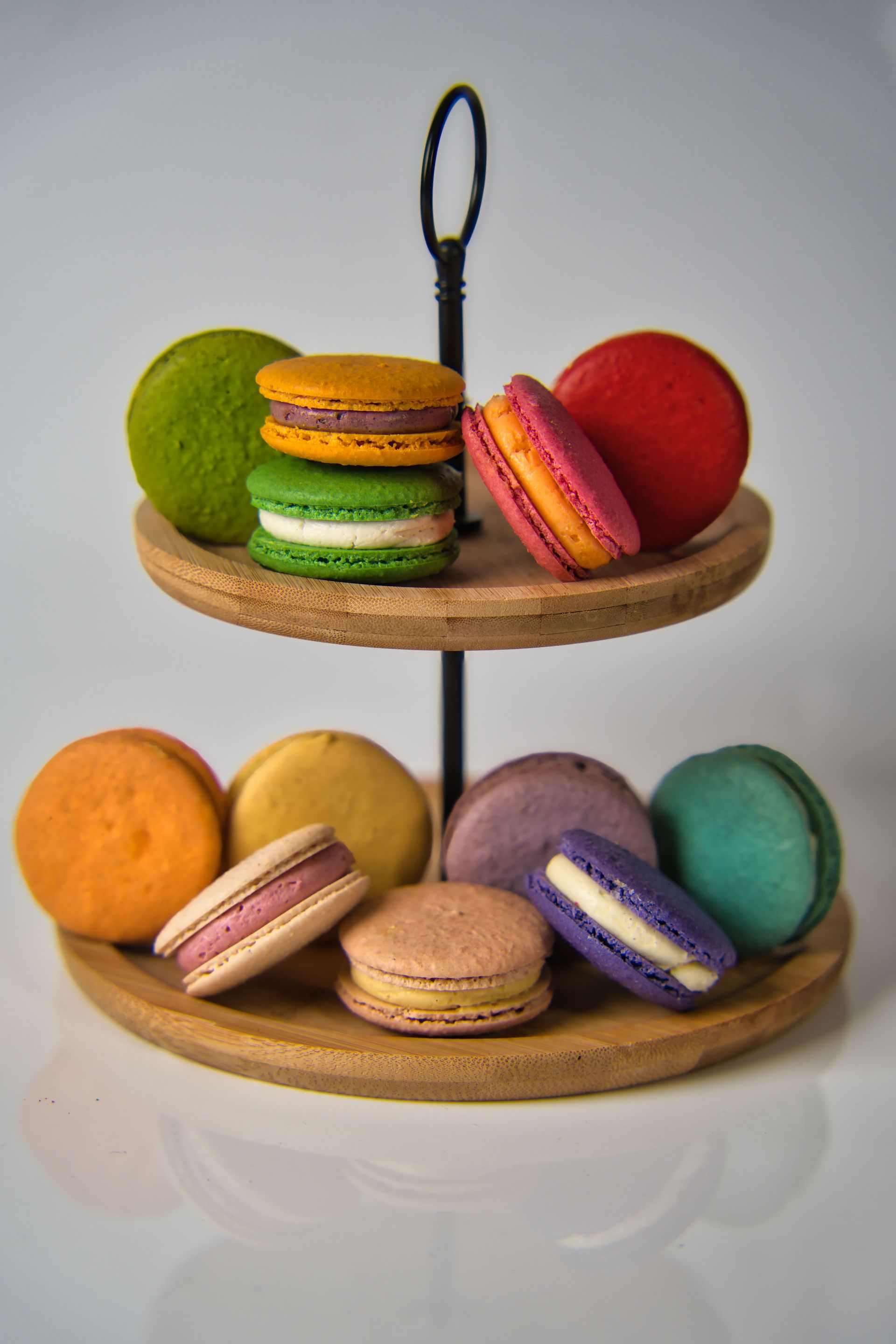 Two-tier stand with colorful macarons on a light background