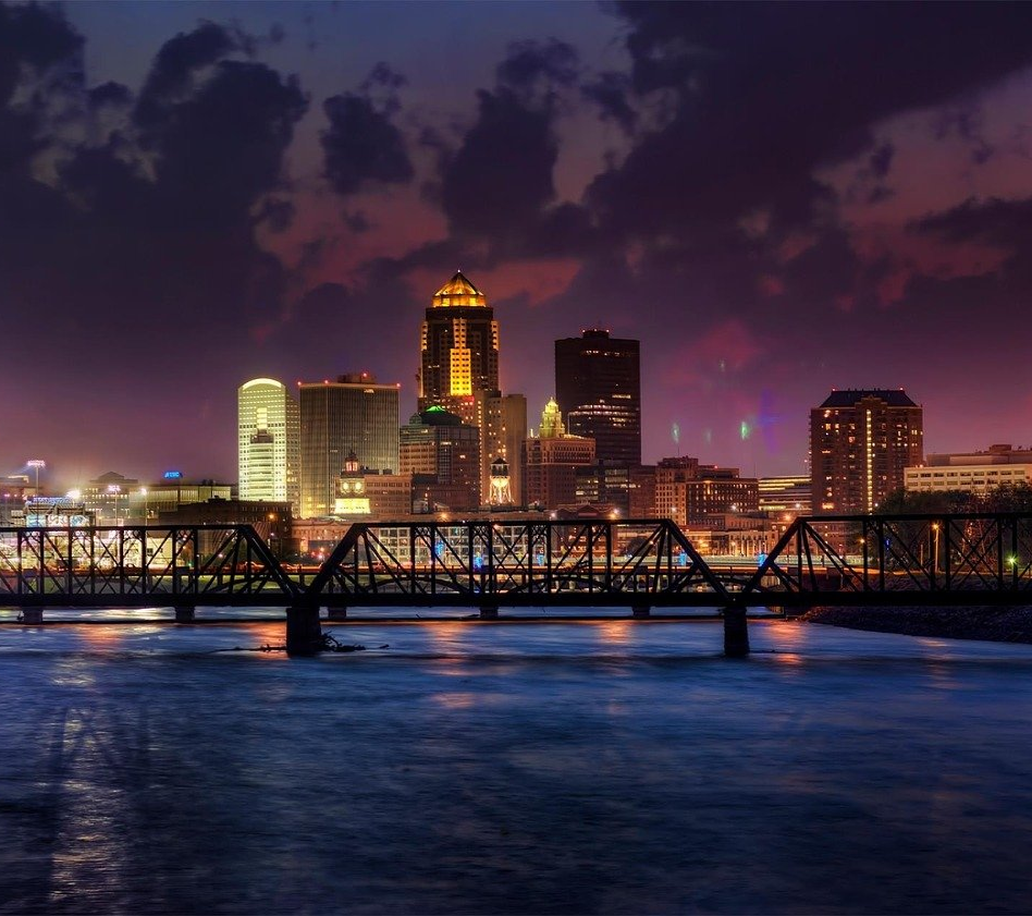 a bridge over a body of water with a city skyline in the background