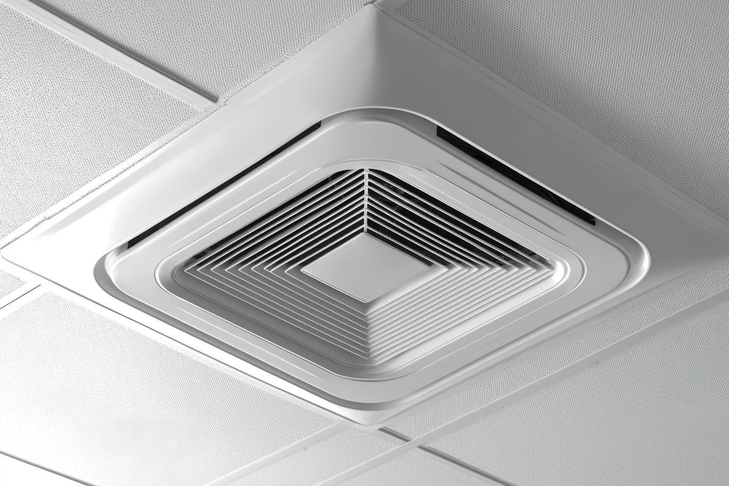 A square white ceiling-mounted HVAC air diffuser with concentric louvers, installed in a tiled drop ceiling.