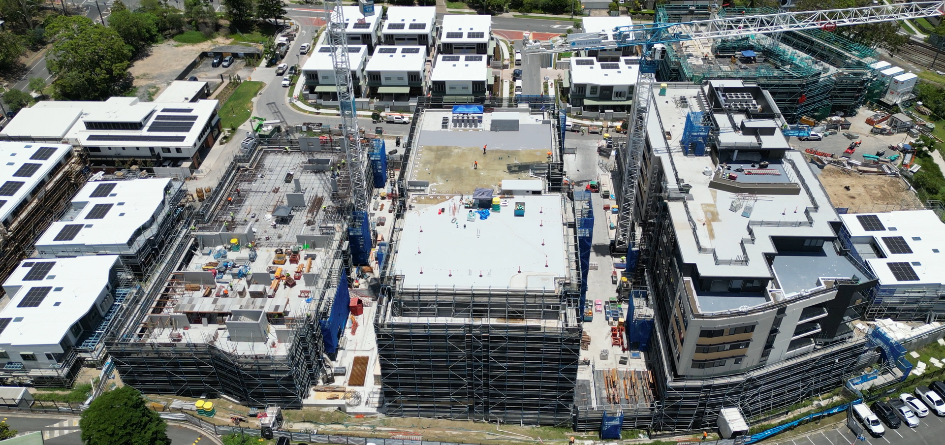 Construction site with scaffolding, safety netting, and a Hutchinson Builders banner.