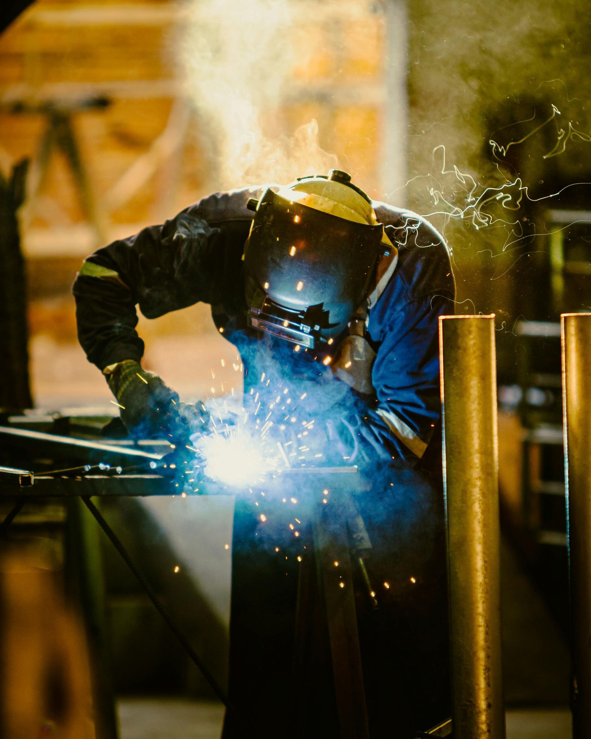 welder in dark colored clothing and welders helmet