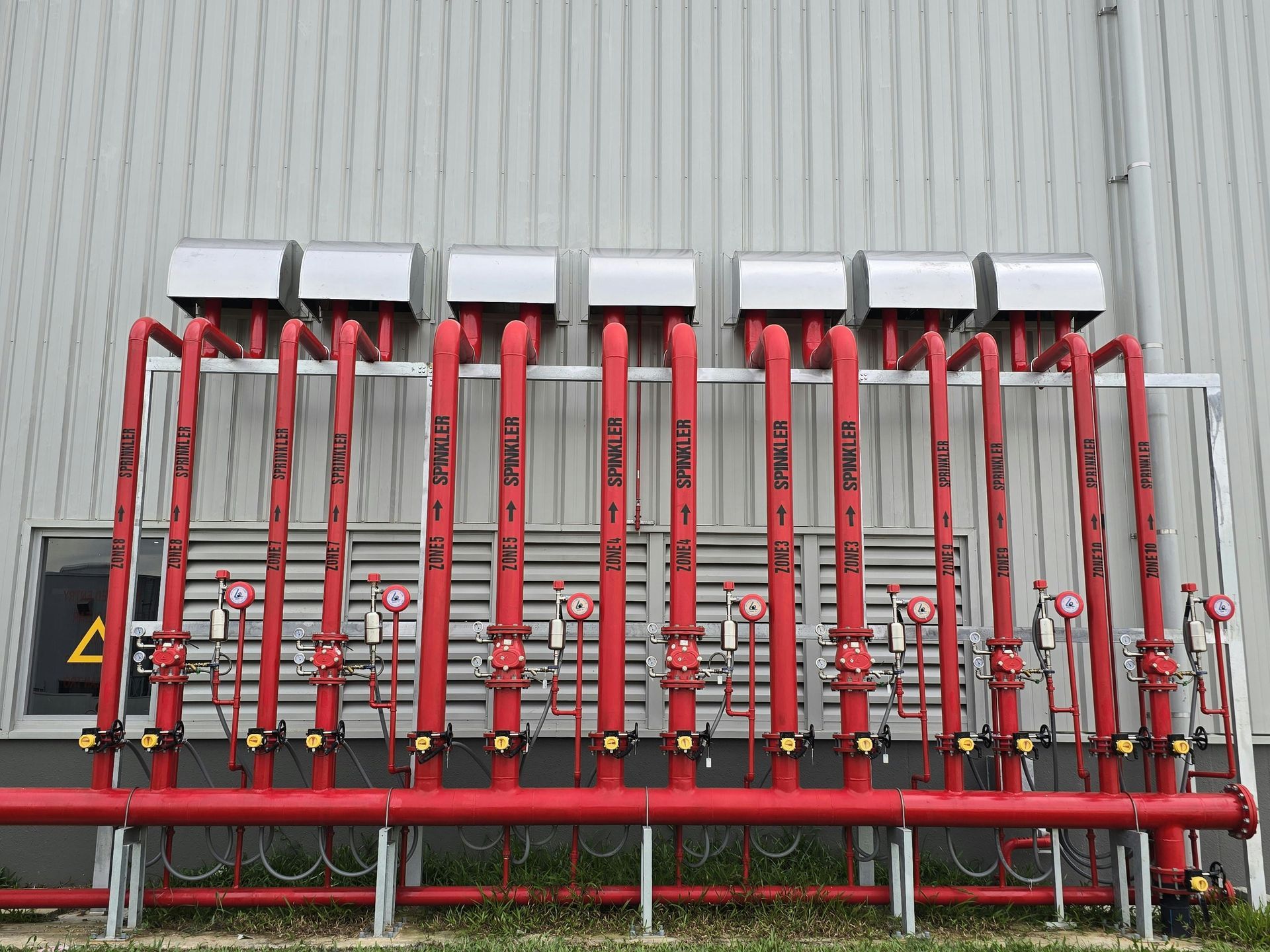 red tube fire suppression system outside a white building