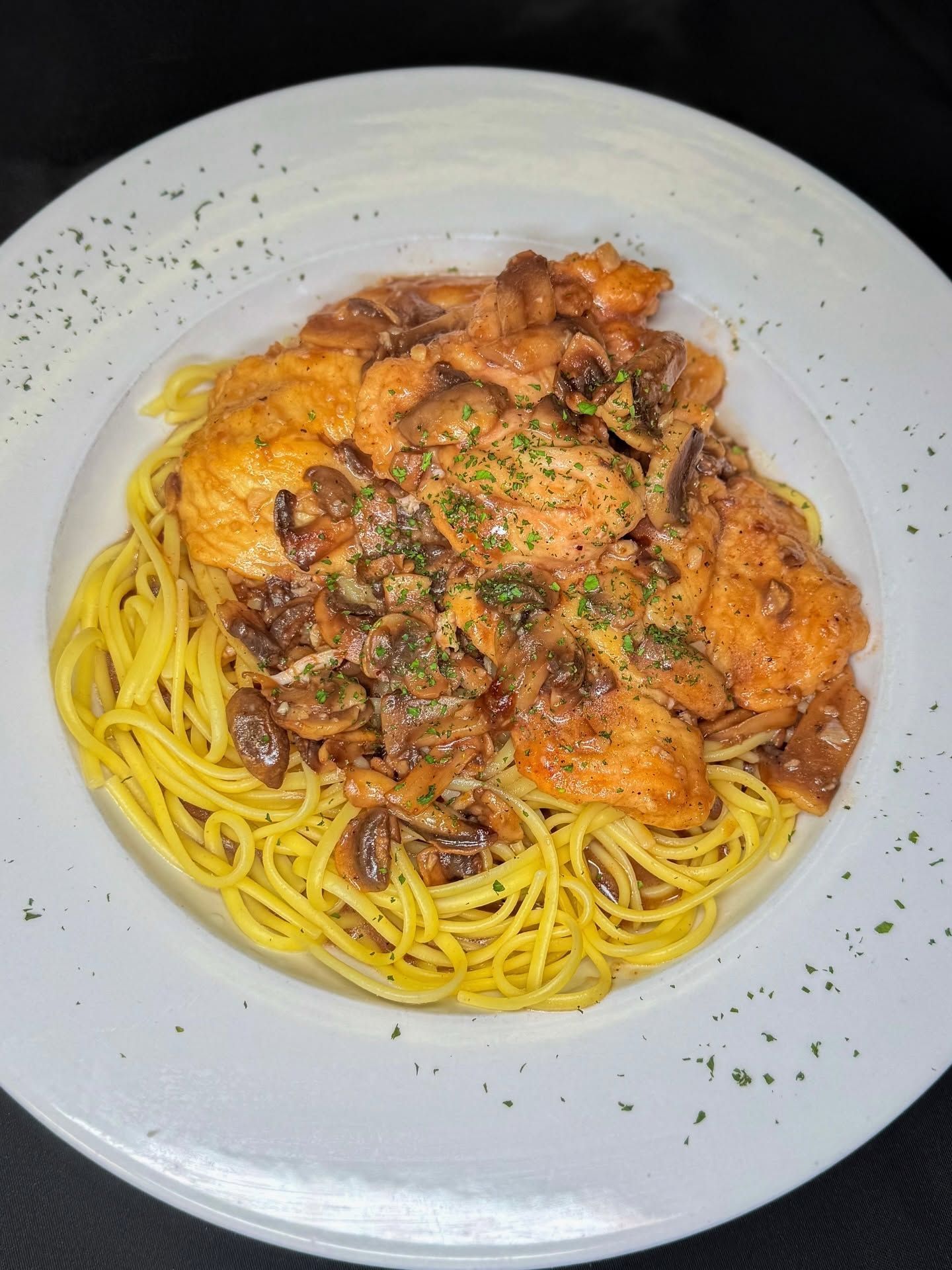 Plate of spaghetti with tomato sauce and herbs on a white dish