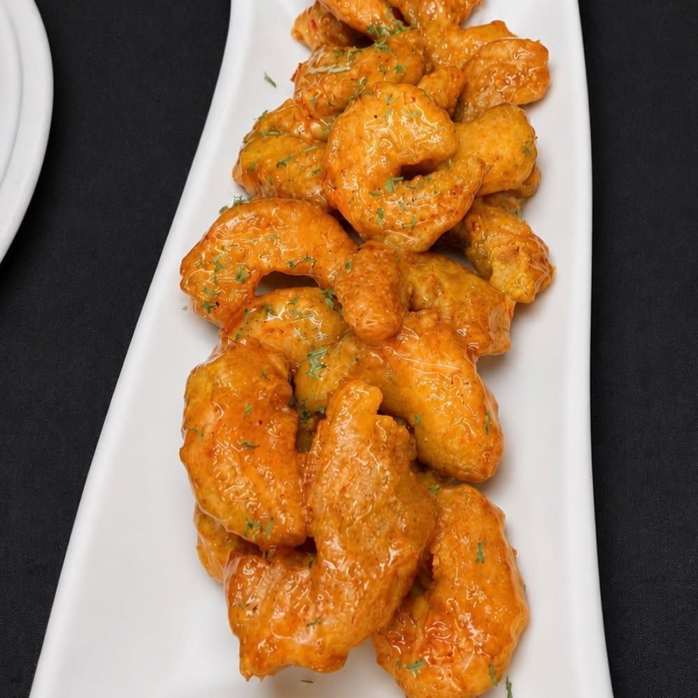Spicy orange fried shrimp served on a white platter