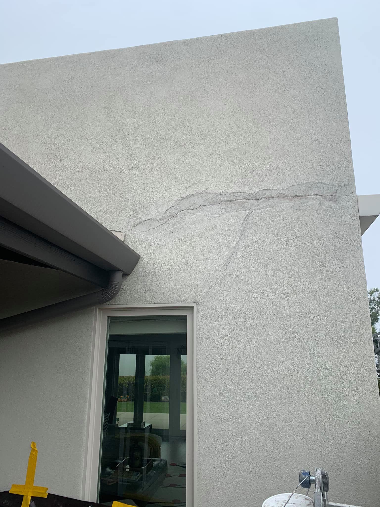 The side of a building with a window and a gutter.
