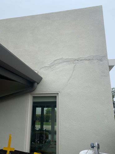 The side of a building with a window and a gutter.