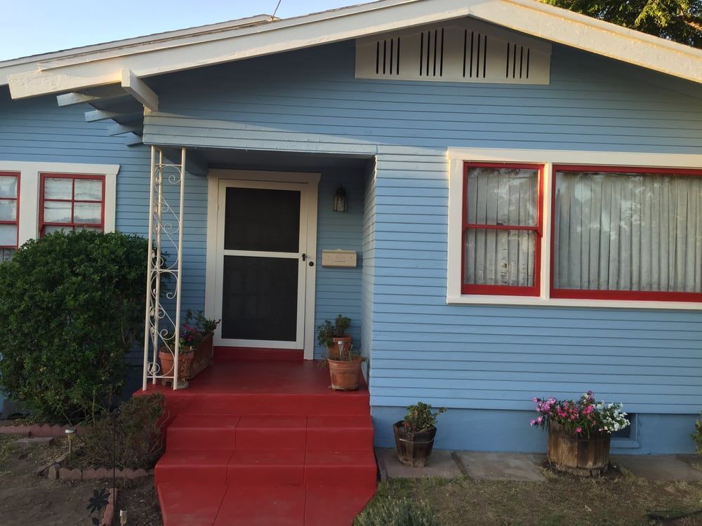 A blue house with red steps and windows