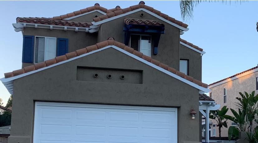 A large house with a white garage door and a tiled roof
