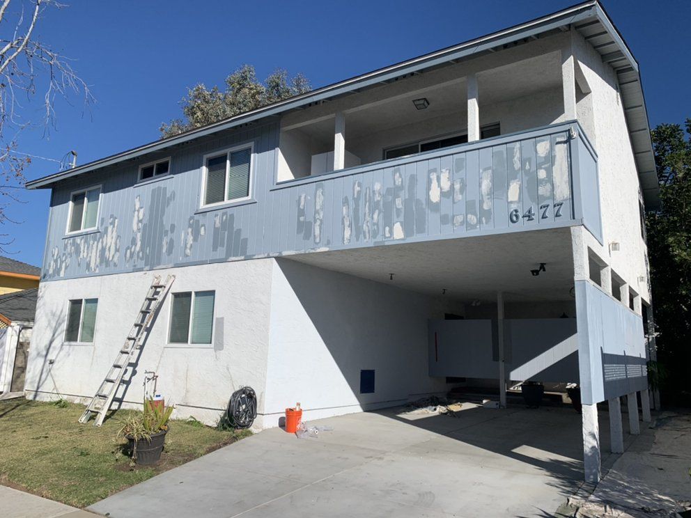 A house with a balcony and a ladder in front of it