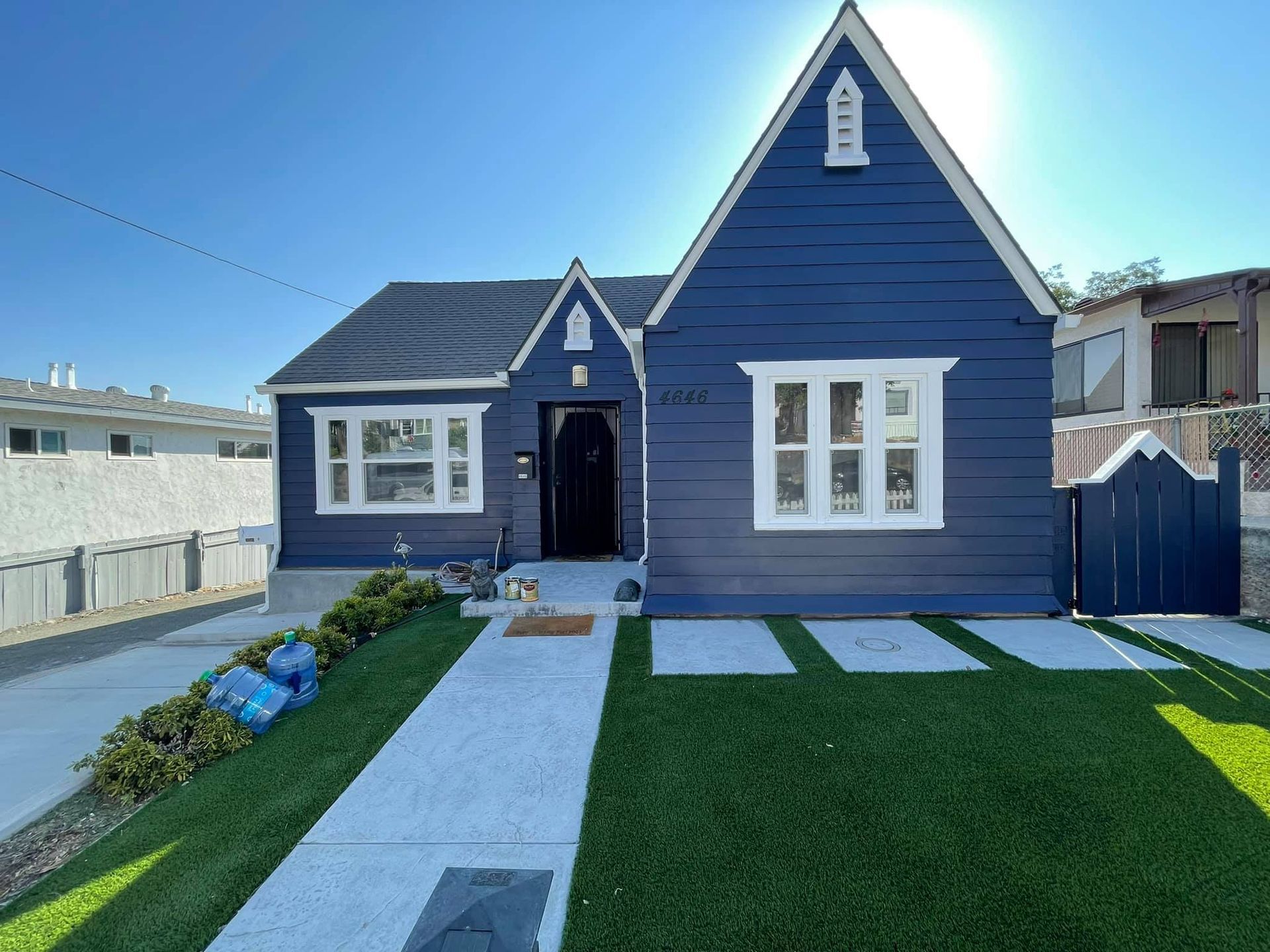 A blue house with white trim and a lawn in front of it