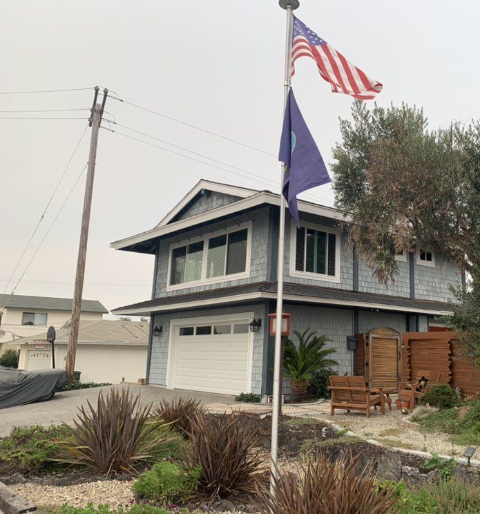An american flag is flying in front of a house