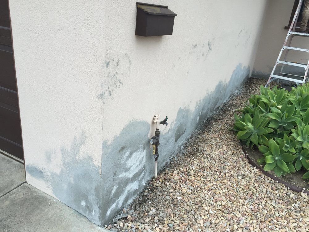 A white wall with a black mailbox on it