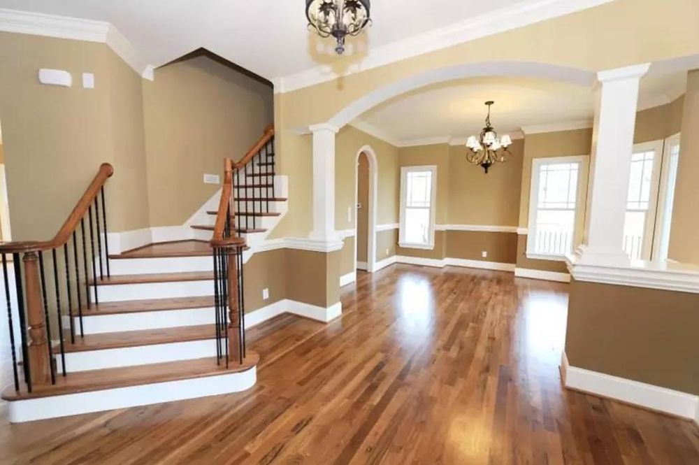 An empty house with hardwood floors and stairs