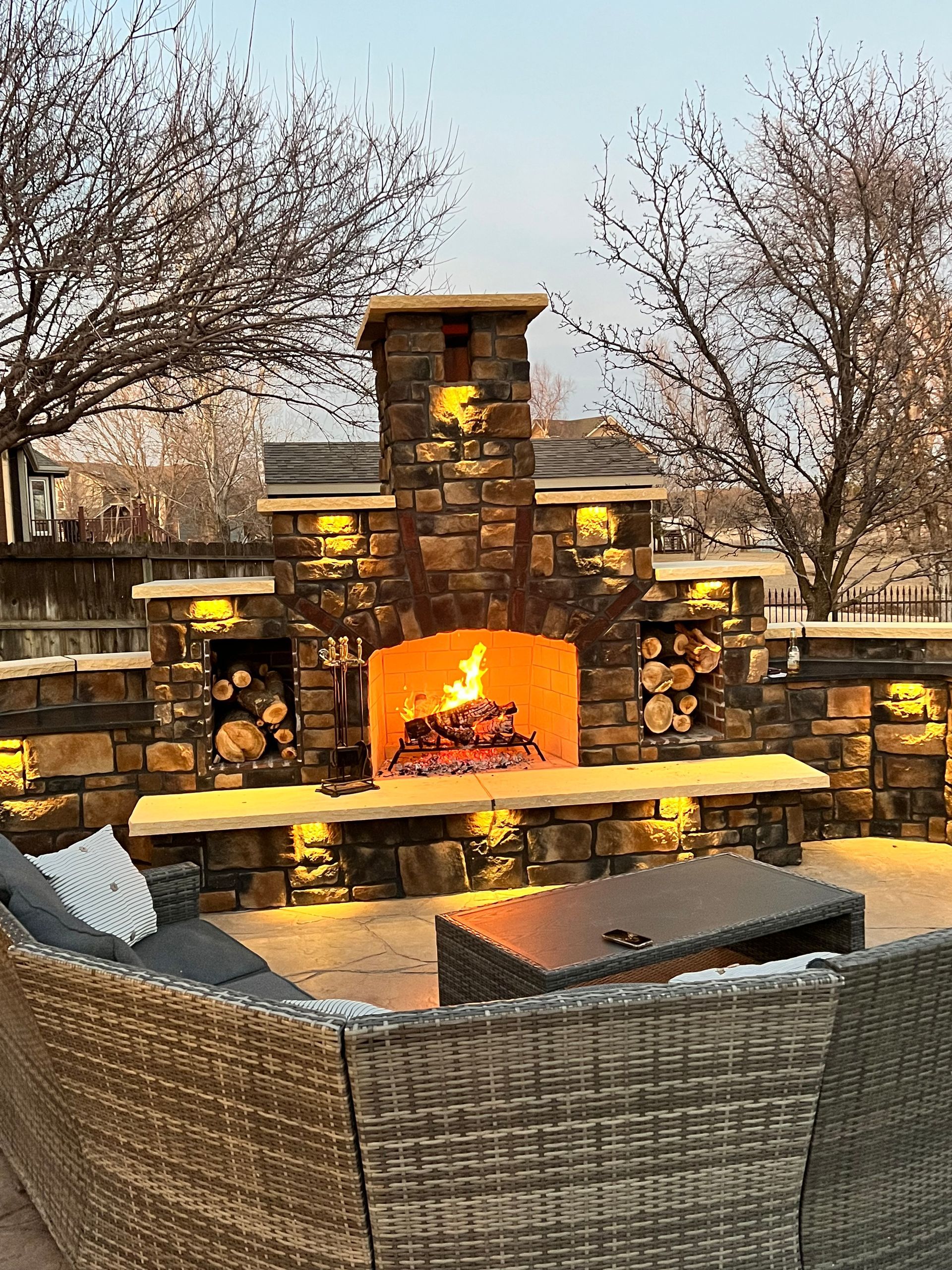 Stone masonry entry columns with lantern lights at a Kansas home built by B&B Builders