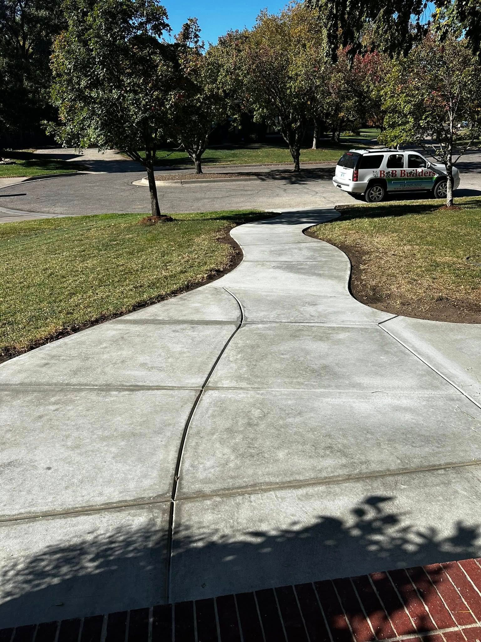 Curved concrete driveway and walkway sloped away from the house for proper drainage