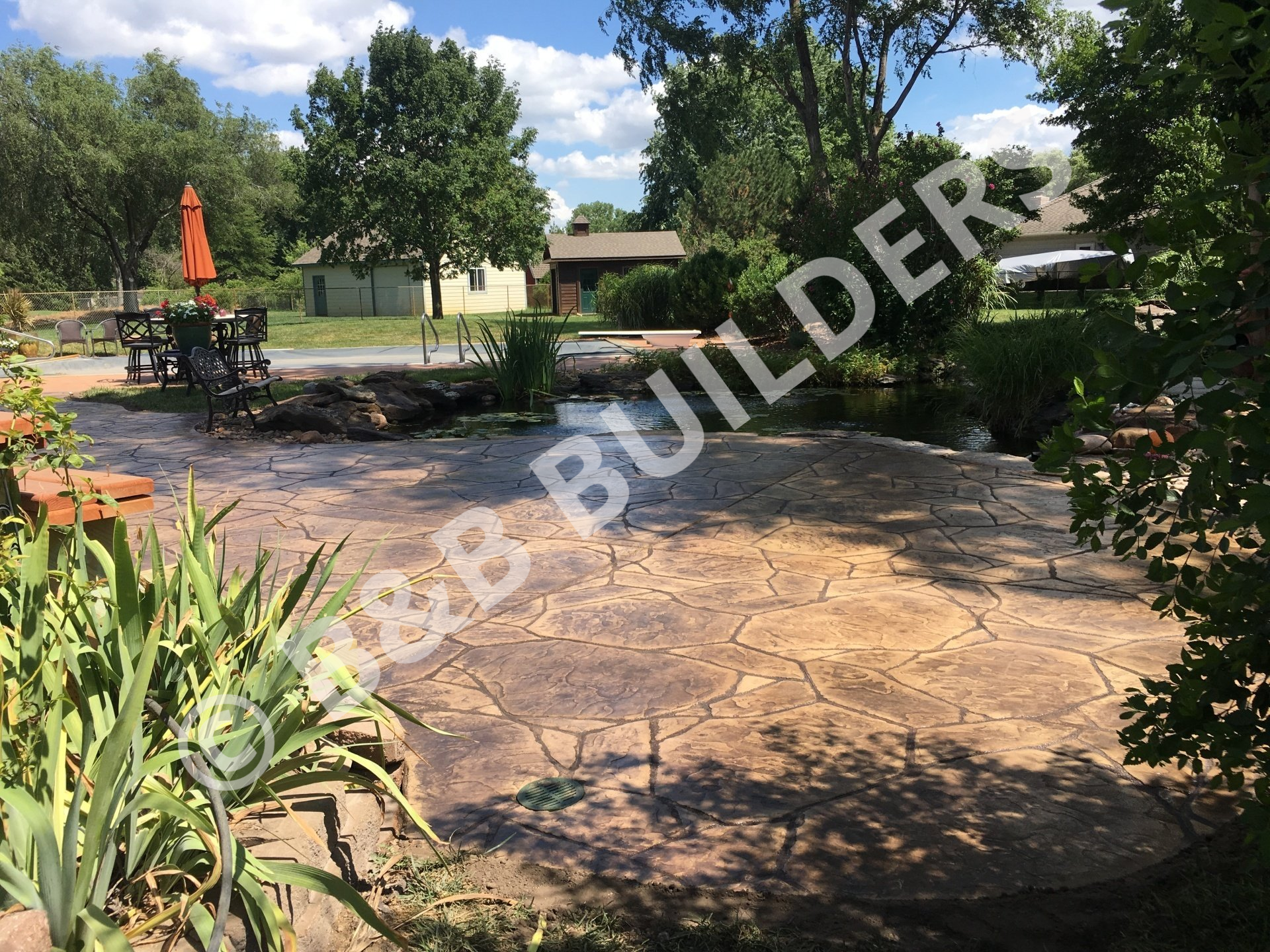 A  brown stamped concrete faux stone curved patio