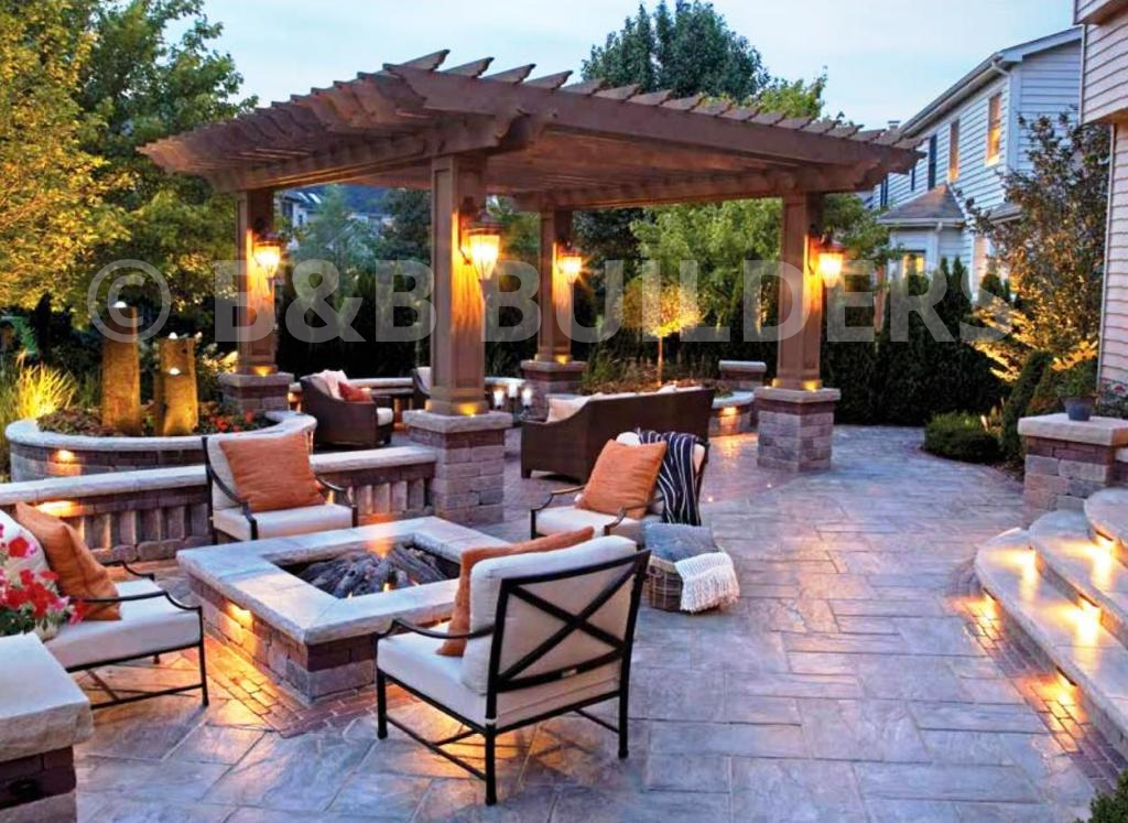 A patio with a pergola and a fire pit