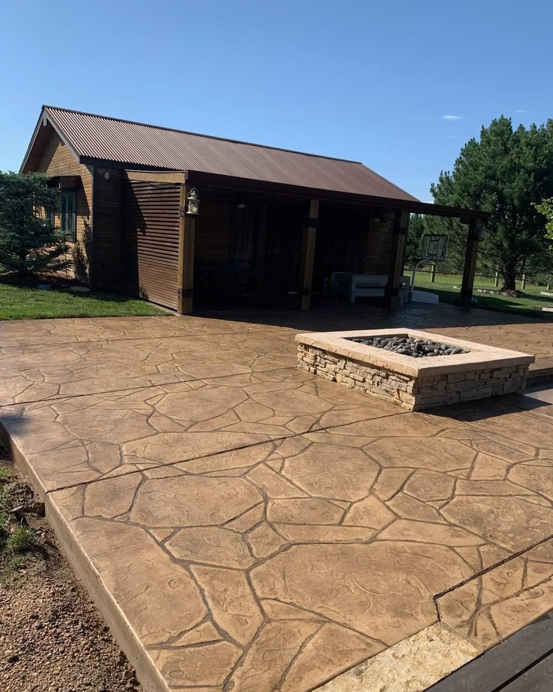 A pergola overlooking a lake with a fire pit in the middle