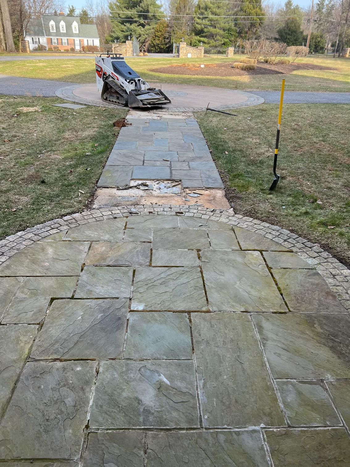A shadow of a person is cast on a stone walkway.