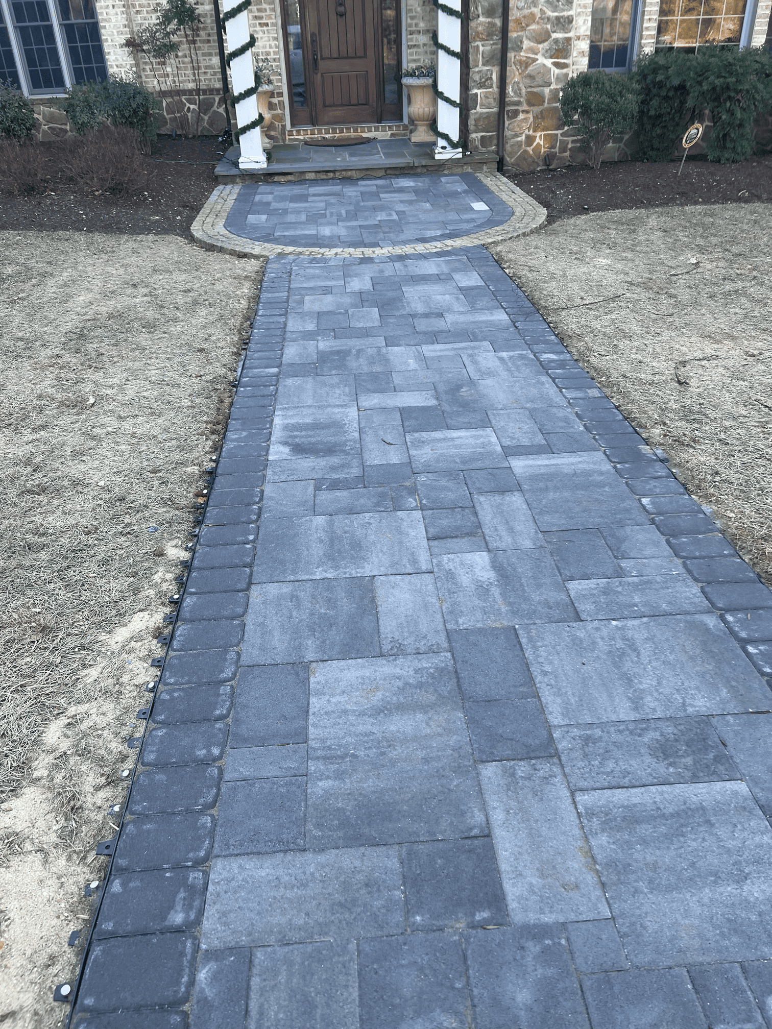 A brick walkway leading to the front door of a house.