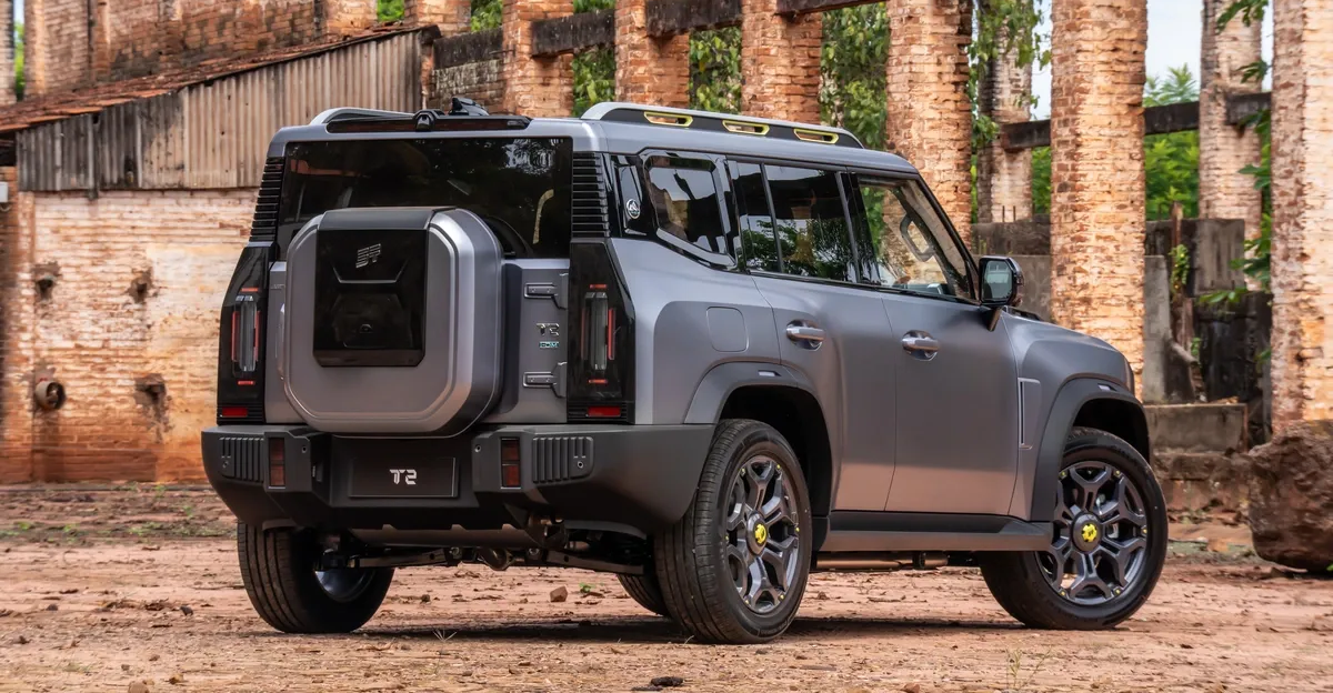 Gray off-road SUV parked in front of a weathered brick building, viewed from the rear side