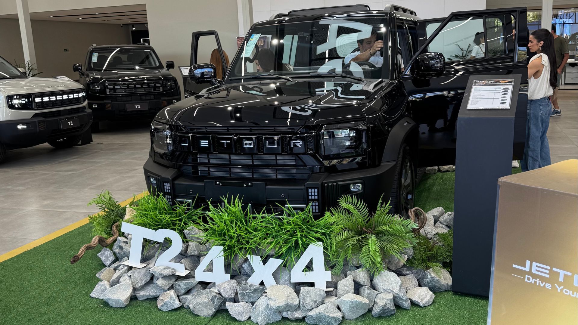 Black Jeep display in showroom with plants and large 4x4 sign in front